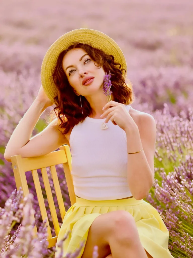 Mujer con sombrero en una silla en un campo de lavanda