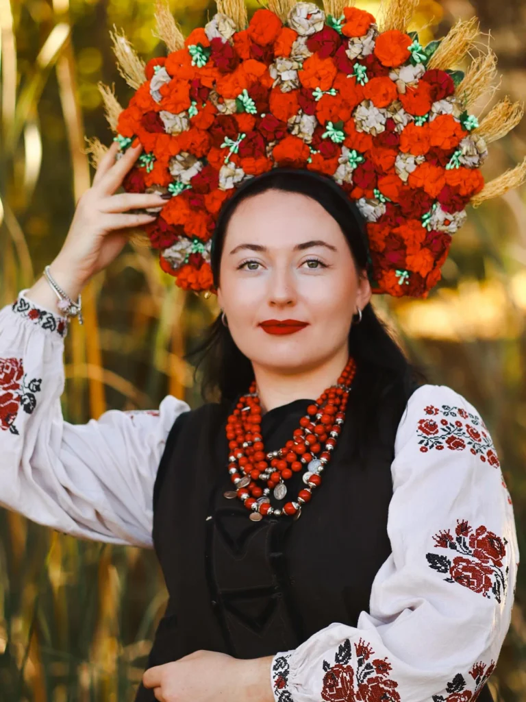 Retrato de mujer con corona de flores rojas y camisa bordada
