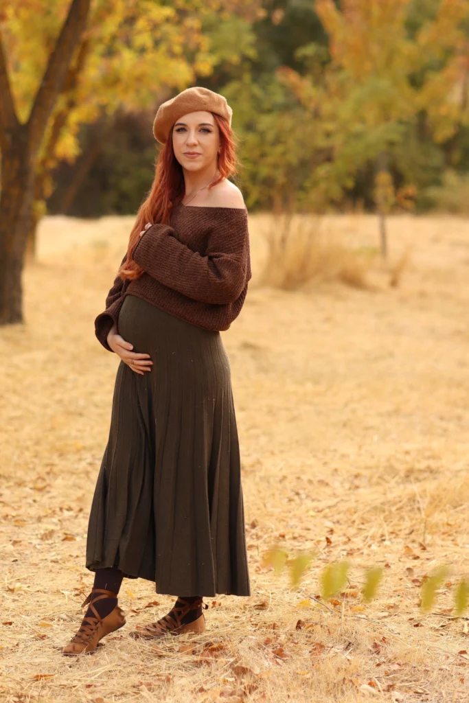Mujer con vestido marrón paseando por un campo dorado al atardecer